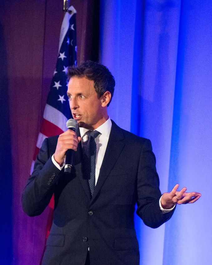 Seth Meyers speaks in a microphone