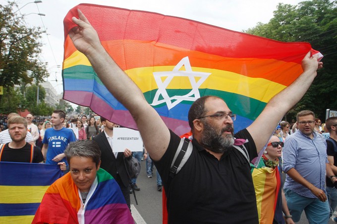 A Man Holds A Rainbow Flag