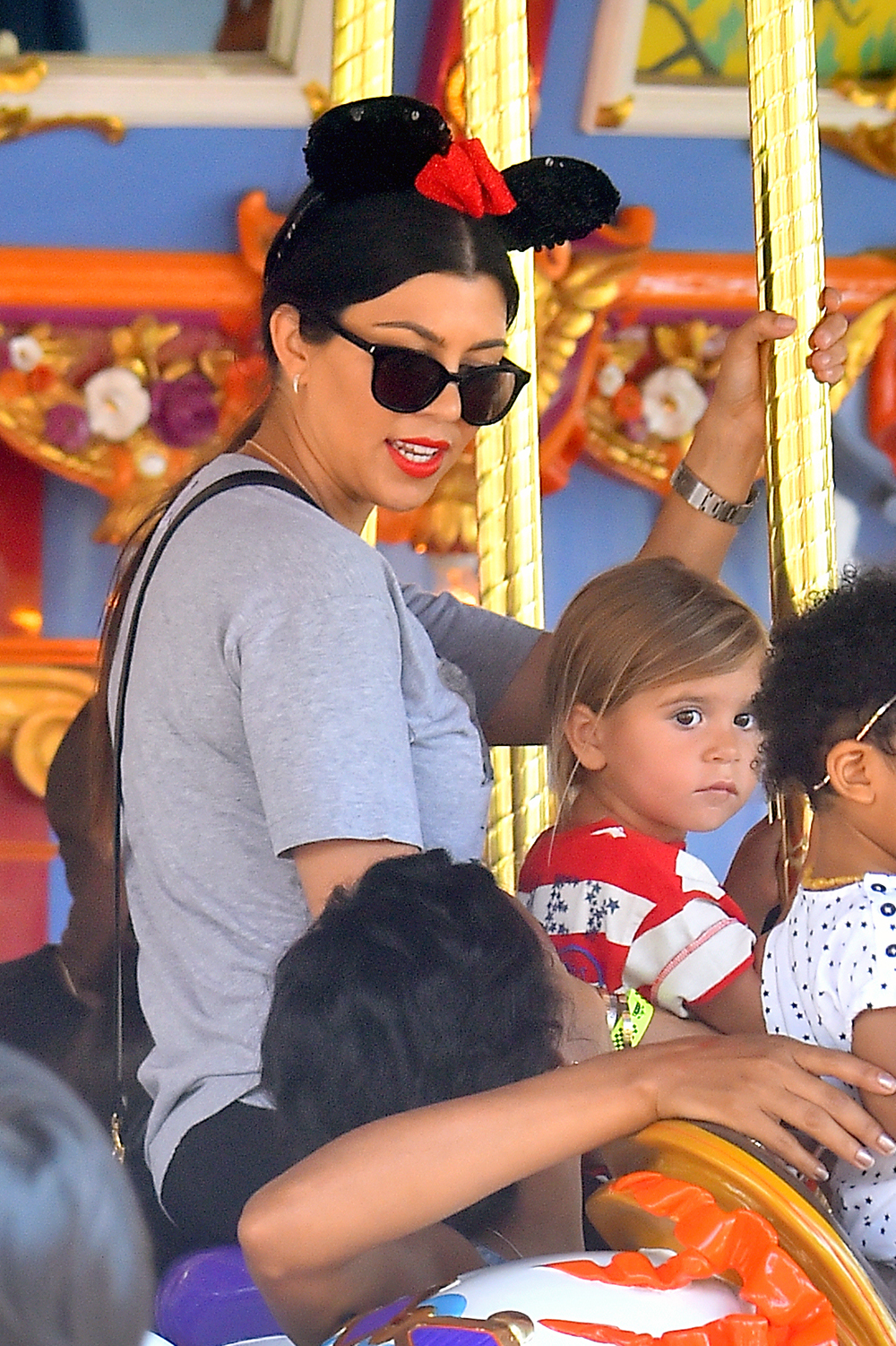 Kim Kardashian and her family enjoy a carousel ride at disneyland on North's 2nd birthday