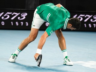 Serbia's Novak Djokovic smashes his racket during his quarterfinal match against Germany's Alexander Zverev at the Australian Open tennis championship in Melbourne, Australia, Tuesday, Feb. 16, 2021.(AP Photo/Andy Brownbill)