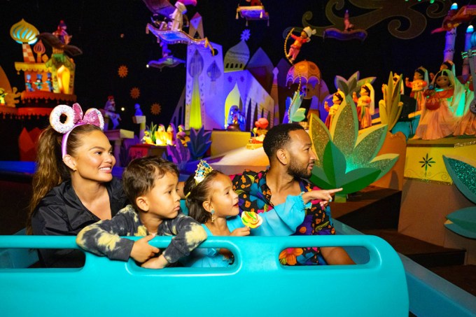 Chrissy Teigen & John Legend with their kids on a ride at Disneyland