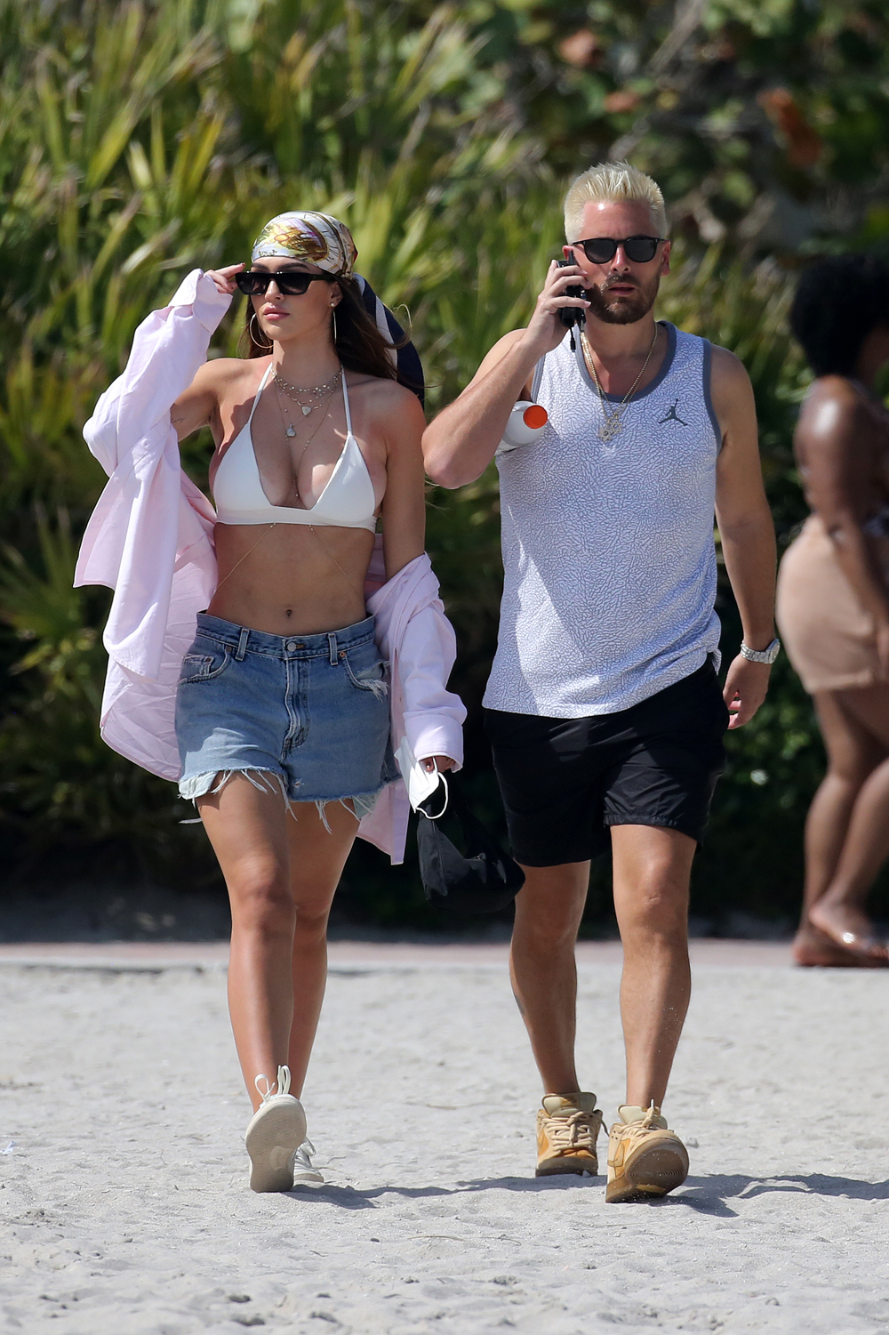 Bikini clad Amelia Hamlin happily applies sunscreen to boyfriend Scott Disick as they relax on the beach on Valentine's Day in Miami