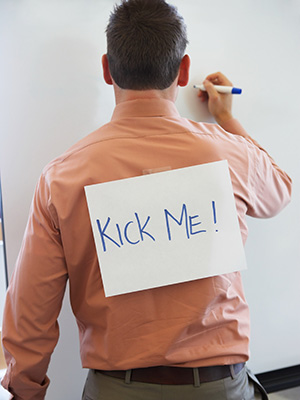 man wearing kick me sign