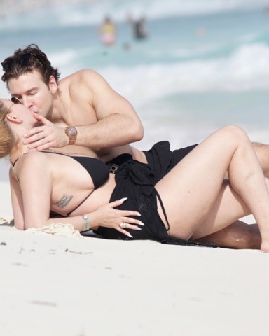 EXCLUSIVE: Shanna Moakler proves that Kourtney Kardashian and Travis Barker aren’t the only hot couple around - as she kisses her younger boyfriend on a beach in Mexico. The former pageant queen looked head over heels as she smooched on the sand with boyfriend Matthew Rondeau during a romantic vacation in Cancun. Shanna, 46, who was married to the Blink-182 drummer between 2004 and 2008 and had two children with him, looked stunning in a black bikini that she revealed after pulling down her dress. The former Playboy model and actress has had an on-again, off-again relationship with Matthew, 28, since 2000. 16 Dec 2021 Pictured: Shanna Moakler and Matthew Rondeau. Photo credit: MEGA TheMegaAgency.com +1 888 505 6342 (Mega Agency TagID: MEGA814449_045.jpg) [Photo via Mega Agency]