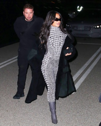 Inglewood, CA  - *EXCLUSIVE*  - Reality star Kim Kardashian is hard to miss in a shimmering catsuit while attending singer SZA’s show at the The Kia Forum in Inglewood with her assistant. Recently Kim posted a photo of Sza in the new ad campaign for her line of body shapers. The award-winning songstress appears in the latest campaign for Skims wearing pieces from the brand's Fits Everybody collection. Kim was seen wearing a grey catsuit, long coat, grey boots and sunglasses as she arrived to the venue on Wednesday nightPictured: Kim KardashianBACKGRID USA 23 MARCH 2023 BYLINE MUST READ: ALEXJR / BACKGRIDUSA: +1 310 798 9111 / usasales@backgrid.comUK: +44 208 344 2007 / uksales@backgrid.com*UK Clients - Pictures Containing ChildrenPlease Pixelate Face Prior To Publication*