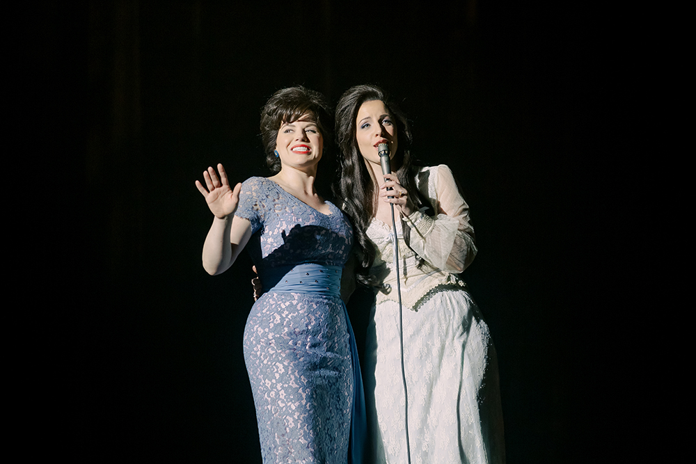 Patsy & Loretta is based on the untold true story of the friendship between two of country music’s greatest icons, Patsy Cline (Megan Hilty) and Loretta Lynn (Jessie Mueller). When they first met, Patsy was already one of the biggest stars in country music while Loretta was just a coal miner’s daughter, starting off with little to her name but a $17 guitar.  Instead of seeing Loretta as competition, Patsy took Loretta under her wings to help her make it in Nashville. Soon, they became close friends, touring together, bonding over their husband troubles and commiserating on being females in the male-dominated music business. Then in 1963, the country music community was struck with a tragedy when at just age 30, Patsy died in a plane crash. Despite the devasting loss of her friend, Loretta continued on in the industry and is today, known as the First Lady of Country Music. To this day, Loretta remains grateful to Patsy for her mentorship and above all, friendship, as the country music trailblazer that paved the way for Loretta