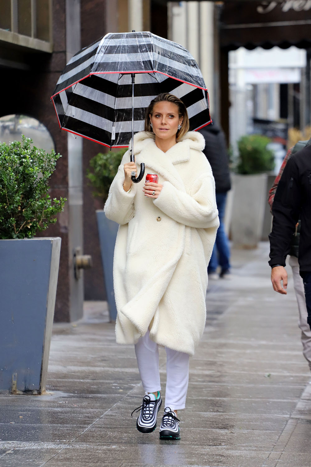 A bundled up Heidi Klum braves the rain with an umbrella and a can of Coke in Los Angeles, California. The newly engaged supermodel was spotted on the set on Germany's Next Topmodel with her sparkler from fianc√© Tom Kaulitz on full display. Wrapped up in an on-trend cream teddy coat, and butterfly earrings, Heidi strolled through Donwtown Los Angeles with a striking striped umbrella and a can of Coca Cola. She had her hair slicked back showing off her beautifully made up face as she made her way to filming the reality show.



Coat ‚Äì Max Mara

Pictured: Heidi Klum
Ref: SPL5064037 130219 NON-EXCLUSIVE
Picture by: SplashNews.com

Splash News and Pictures
Los Angeles: 310-821-2666
New York: 212-619-2666
London: +44 (0)20 7644 7656
Berlin: +49 175 3764 166
photodesk@splashnews.com

World Rights