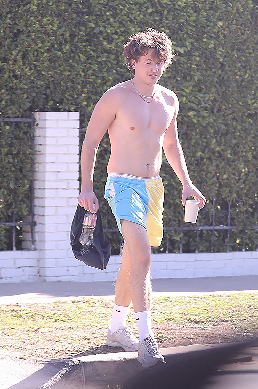 *EXCLUSIVE* A shirtless Charlie Puth shows off his guns while heading out of a private gym