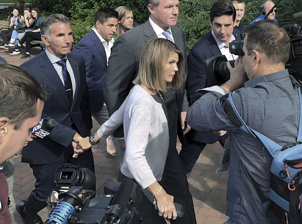 Lori Loughlin depart federal court with her husband, clothing designer Mossimo Giannulli, left, on Tuesday, Aug. 27, 2019, in Boston, after a hearing in a nationwide college admissions bribery scandal. (AP Photo/Philip Marcelo)