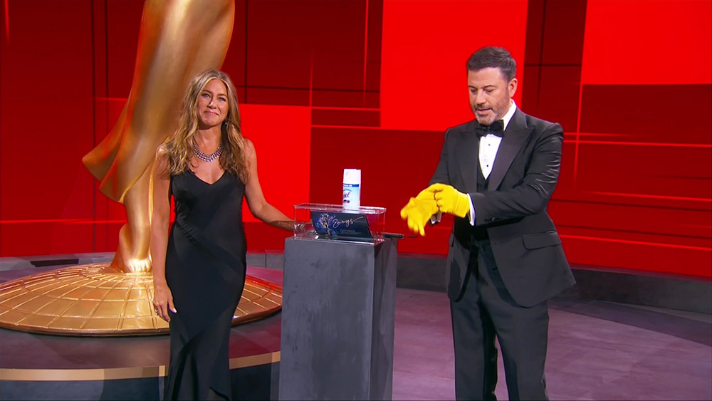 Jennifer Aniston, left, and Jimmy Kimmel sanitize the winner's envelope during the 72nd Emmy Awards telecast on Sunday, Sept. 20, 2020 at 8:00 PM EDT/5:00 PM PDT on ABC. (Invision for the Television Academy/AP)