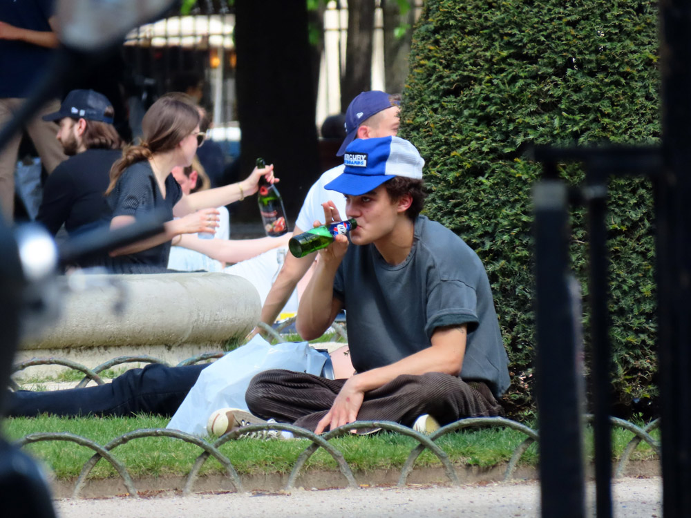 EXCLUSIVE: Jack Depp seen in Paris enjoying the sun in the Place des Vosges garden reading while drinking a beer