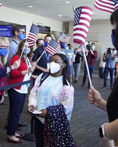 Simone Biles walks to her gate for her flight to the Summer Olympic Games in Tokyo as United Airlines employees wave flags during a send-off event for the U.S. Women's Gymnastics team at the San Francisco International Airport onUS Gymnastics Biles, San Francisco, United States - 14 Jul 2021