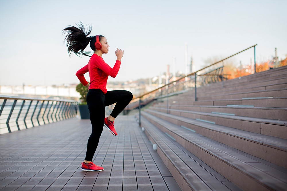 Fitness woman jumping outdoor in urban enviroment