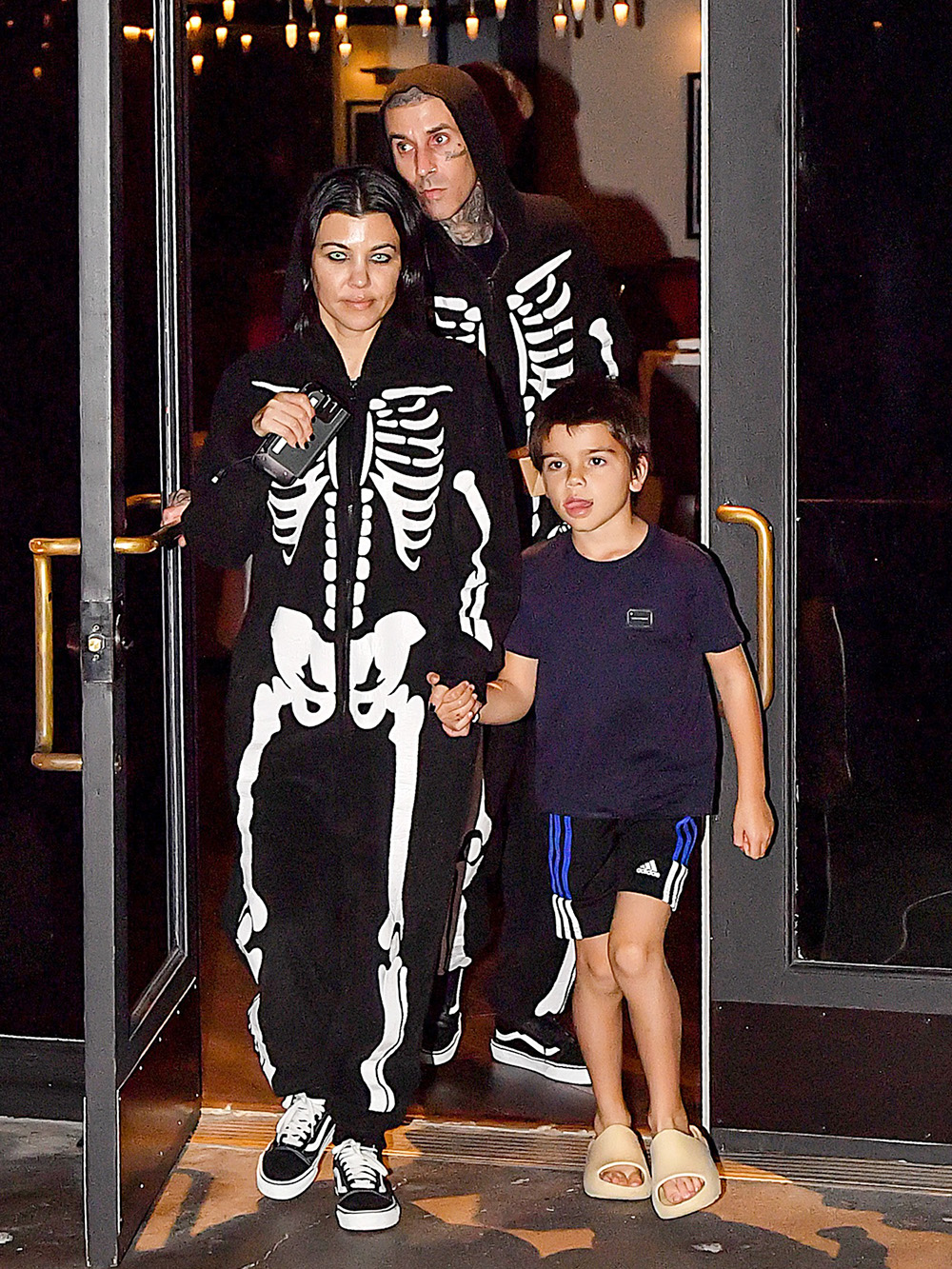 EXCLUSIVE: Kourtney Kardashian & Travis Barker Spotted Wearing Scary Contact Lenses & Skeleton Onsie During Dinner At Their Vegan Restaurant Crossroads In Calabasas, CA.