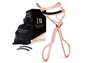 A rose gold eyelash curler with satin bag.