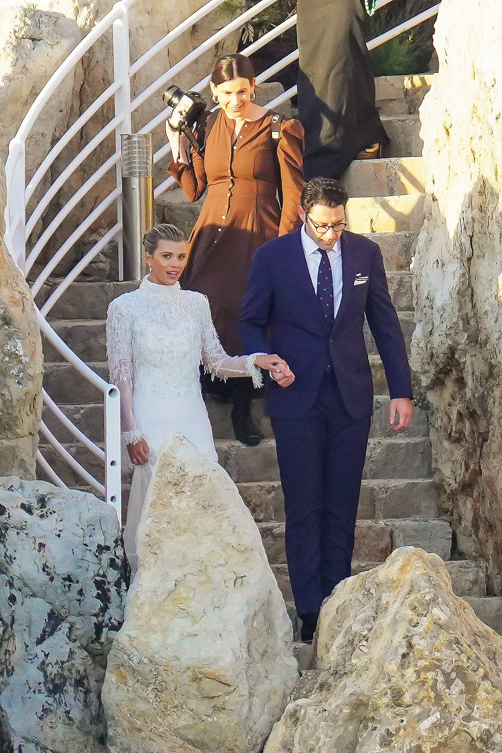 Blushing bride Sofia Richie looks radiant in an elegant white gown as she celebrates her lavish wedding weekend in the French Riviera. The model and daughter of legendary crooner Lionel Richie stepped out with her British fiance Elliot Grainge on Friday evening during their ultra glamorous trip to tie the knot in Antibes. It was unclear whether the happy couple were heading off to a fancy rehearsal dinner, or were dressed up for the nuptials. The stylish 24-year-old chose a demure, delicately beaded floor length ensemble for the occasion paired with white stilettos and wore her long hair in a chic up do. Her record executive groom, 30, looked dapper in a dark suit and tie as they were snapped by their team of photographers at their swanky hotel at sunset. Among the slew of A-list guests jetting in to watch them exchange vows are Cameron Diaz and Benji Madden, Sofia’s sister Nicole Richie and husband Joel Madden, as well as her father Lionel Richie and brother Miles. 21 Apr 2023 Pictured: Sofia Richie , Elliot Grainge. Photo credit: EliotPress / MEGA TheMegaAgency.com +1 888 505 6342 (Mega Agency TagID: MEGA971732_027.jpg) [Photo via Mega Agency]