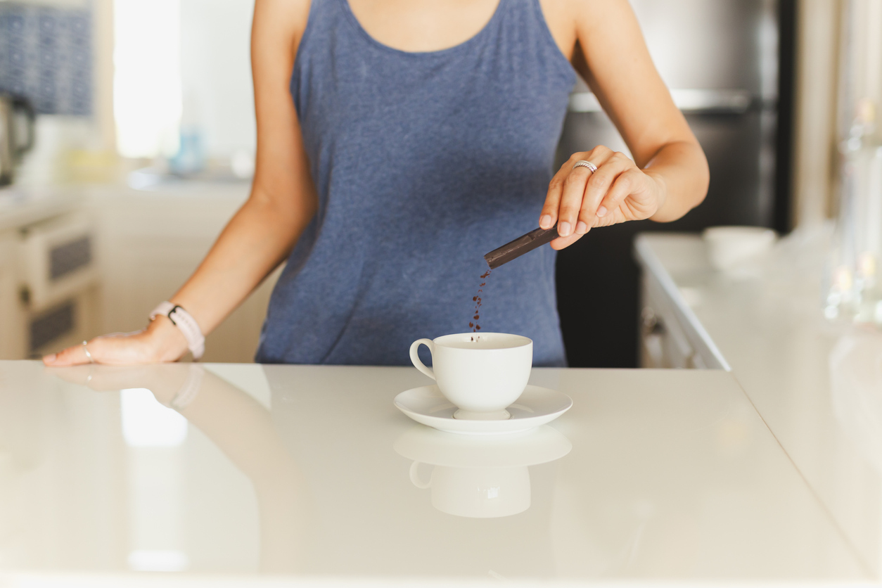A woman prepares a packet of instant coffee
