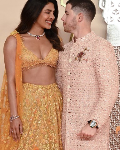 Indian actress Priyanka Chopra Jonas (L) and her husband American singer-songwriter and actor Nick Jonas (R) pose for photos as they arrive to attend the wedding ceremony of billionaire tycoon and Chairman of Reliance Industries Mukesh Ambani's son Anant Ambani and Radhika Merchant in Mumbai on July 12, 2024. Socialite sisters Kim and Khloe Kardashian were among the global celebrities spotted in India on July 12 to attend a lavish three-day wedding ceremony staged by Asia's richest man Mukesh Ambani. (Photo by SUJIT JAISWAL / AFP) (Photo by SUJIT JAISWAL/AFP via Getty Images)