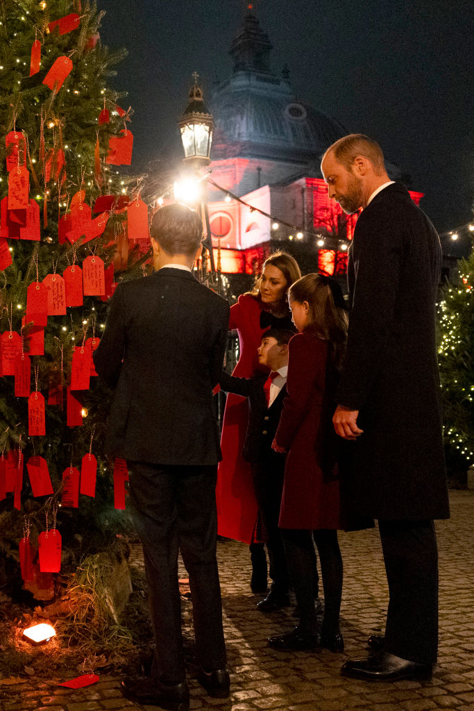 LONDON, ENGLAND - DECEMBER 06:  The Prince and Princess of Wales with their children Prince George, Princess Charlotte and Prince Louis look at messages on the Kindness Tree ahead  of the Together At Christmas carol service at Westminster Abbey on December 6, 2024 in London, England. The Prince and Princess of Wales, along with other members of the Royal Family, attended the annual carol service. Led by The Princess and supported by The Royal Foundation, the event offered a chance to pause and reflect on the profound values of love, compassion, and the vital connections we share—particularly during life's most challenging moments. The service also highlighted remarkable individuals from across the UK who have demonstrated extraordinary kindness, empathy, and support within their communities. (Photo by Jordan Pettitt - WPA Pool/Getty Images)