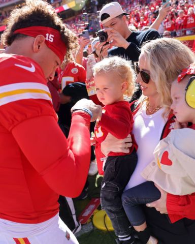 KANSAS CITY, MISSOURI - NOVEMBER 10: Patrick Mahomes #15 of the Kansas City Chiefs fist bumps his son, Bronze, while his wife and daughter, Brittany and Sterling, watch prior to a game against the Denver Broncos at GEHA Field at Arrowhead Stadium on November 10, 2024 in Kansas City, Missouri. (Photo by Jamie Squire/Getty Images)