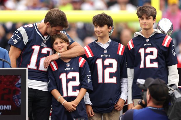 FOXBOROUGH, MASSACHUSETTS - SEPTEMBER 10: Former New England Patriots quarterback Tom Brady kisses his daughter, Vivian, while his sons, Benjamin and Jack, look on during a ceremony honoring Brady at halftime of New England's game against the Philadelphia Eagles at Gillette Stadium on September 10, 2023 in Foxborough, Massachusetts. (Photo by Maddie Meyer/Getty Images)