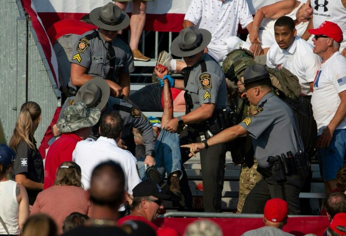 A person is removed by state police from the stands after shots were fired