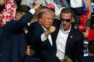 Republican candidate Donald Trump is seen with what appears to be blood on his face surrounded by secret service agents as he is taken off the stage at a campaign event at Butler Farm Show Inc. in Butler, Pennsylvania, July 13, 2024. Republican candidate Donald Trump was evacuated from the stage at today's rally after what sounded like shots rang out at the event in Pennsylvania, according to AFP.The former US president was seen with blood on his right ear as he was surrounded by security agents, who hustled him off the stage as he pumped his first to the crowd.Trump was bundled into an SUV and driven away. (Photo by Rebecca DROKE / AFP) (Photo by REBECCA DROKE/AFP via Getty Images)