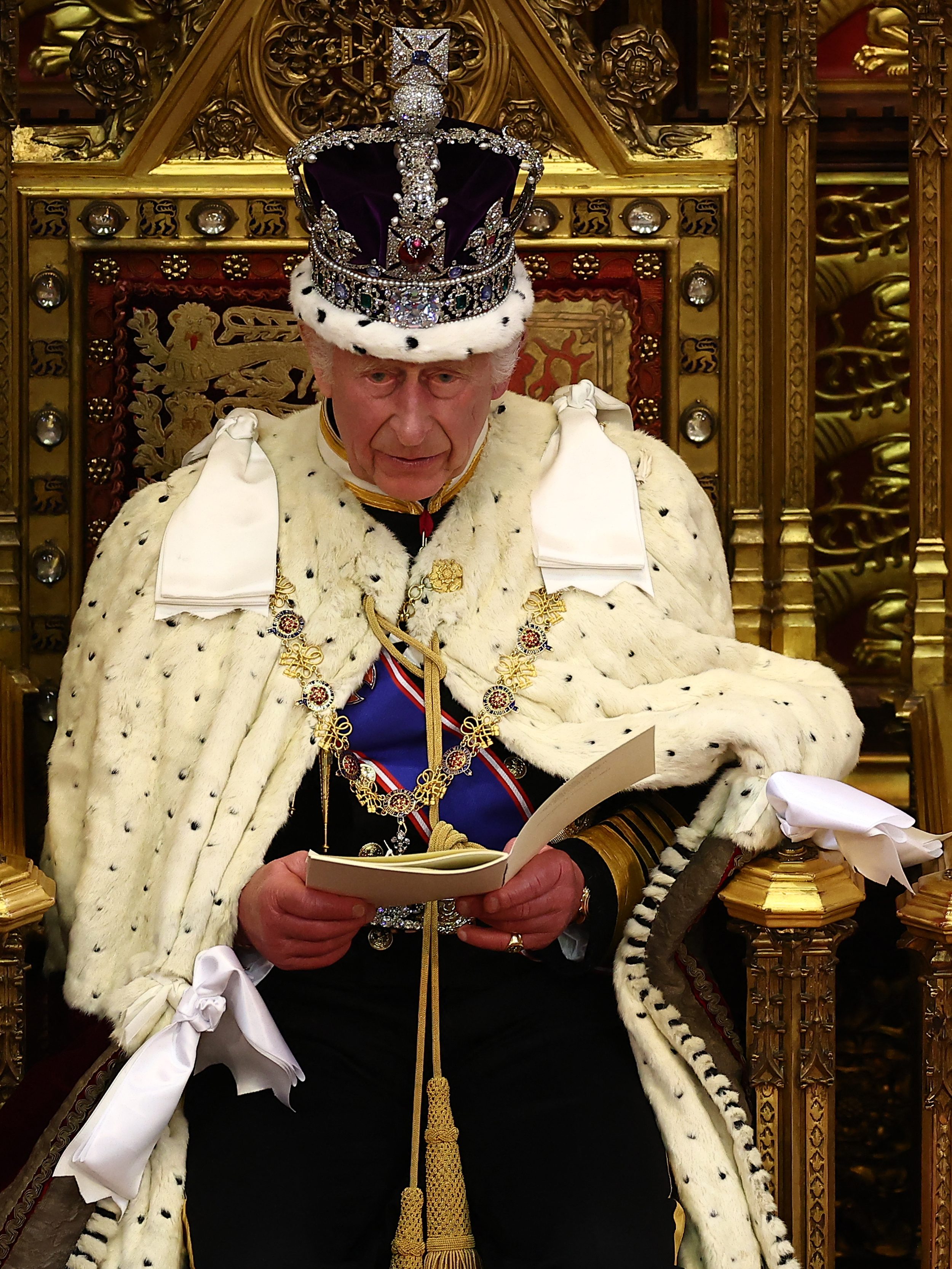 Britain's King Charles III, wearing the Imperial State Crown and the Robe of State, sits alongside Britain's Queen Camilla, wearing the George IV State Diadem, as he reads the King's Speech from the The Sovereign's Throne in the House of Lords chamber, during the State Opening of Parliament, at the Houses of Parliament, in London, on July 17, 2024. (Photo by HENRY NICHOLLS / POOL / AFP) (Photo by HENRY NICHOLLS/POOL/AFP via Getty Images)