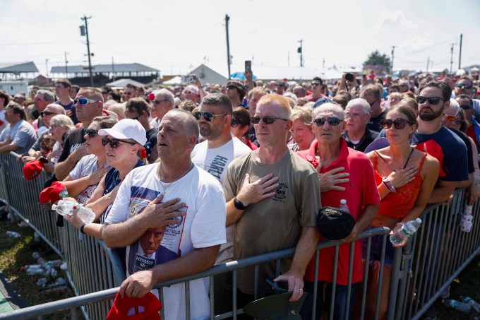 People participate in the pledge of allegiance at a campaign rally for Donald Trump