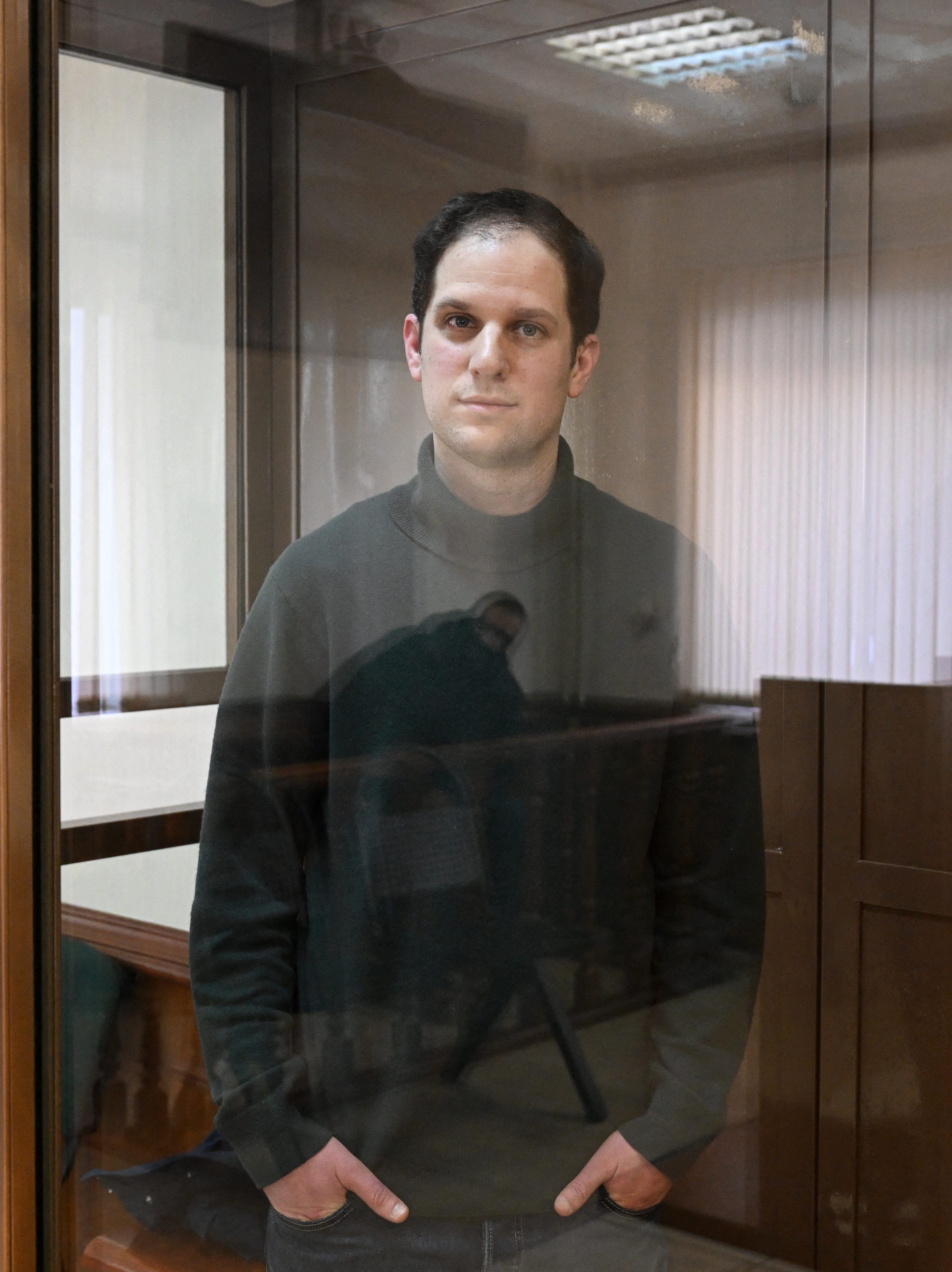 US journalist Evan Gershkovich, arrested on espionage charges, looks out from inside a defendants' cage before a hearing to consider an appeal on his extended pre-trial detention, at the Moscow City Court in Moscow on February 20, 2024. Wall Street Journal reporter Evan Gershkovich was detained last March on spying charges during a reporting trip to the Urals. (Photo by NATALIA KOLESNIKOVA / AFP) (Photo by NATALIA KOLESNIKOVA/AFP via Getty Images)