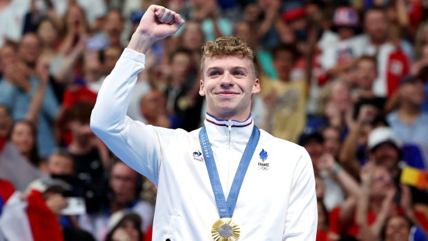 NANTERRE, FRANCE - JULY 28: Gold Medalist Leon Marchand of Team France celebrates on the podium during the Swimming medal ceremony after the Men’s 400m Individual Medley Final on day two of the Olympic Games Paris 2024 at Paris La Defense Arena on July 28, 2024 in Nanterre, France. (Photo by Quinn Rooney/Getty Images)