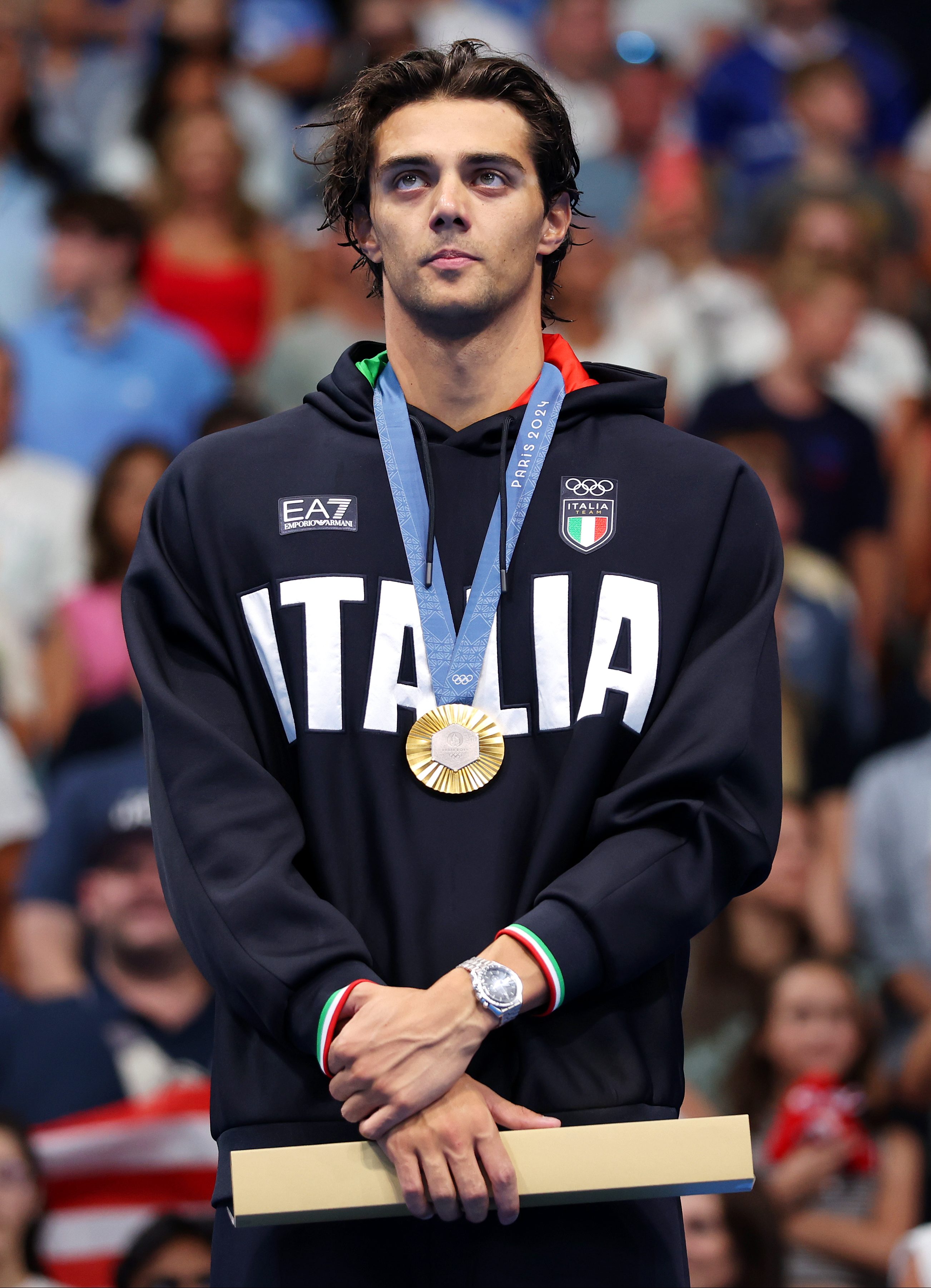 Thomas Ceccon of Team Italy stands on the podium during the Swimming medal ceremony