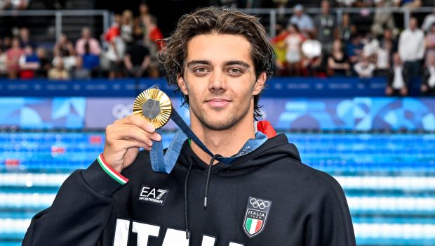 Thomas Ceccon with his gold medal after competing in the swimming 100m Backstroke Men Final