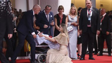 Angelina Jolie speaks to a disabled person at the 81st Venice International Film Festival