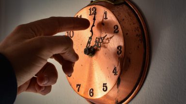 A man changing time on a clock is seen in LAquila, Italy, on March 24, 2023. On march 26th (last march sunday) solar time will replace daylight saving time and people around the world will move one hour ahead hands of clocks.  (Photo by Lorenzo Di Cola/NurPhoto via Getty Images)