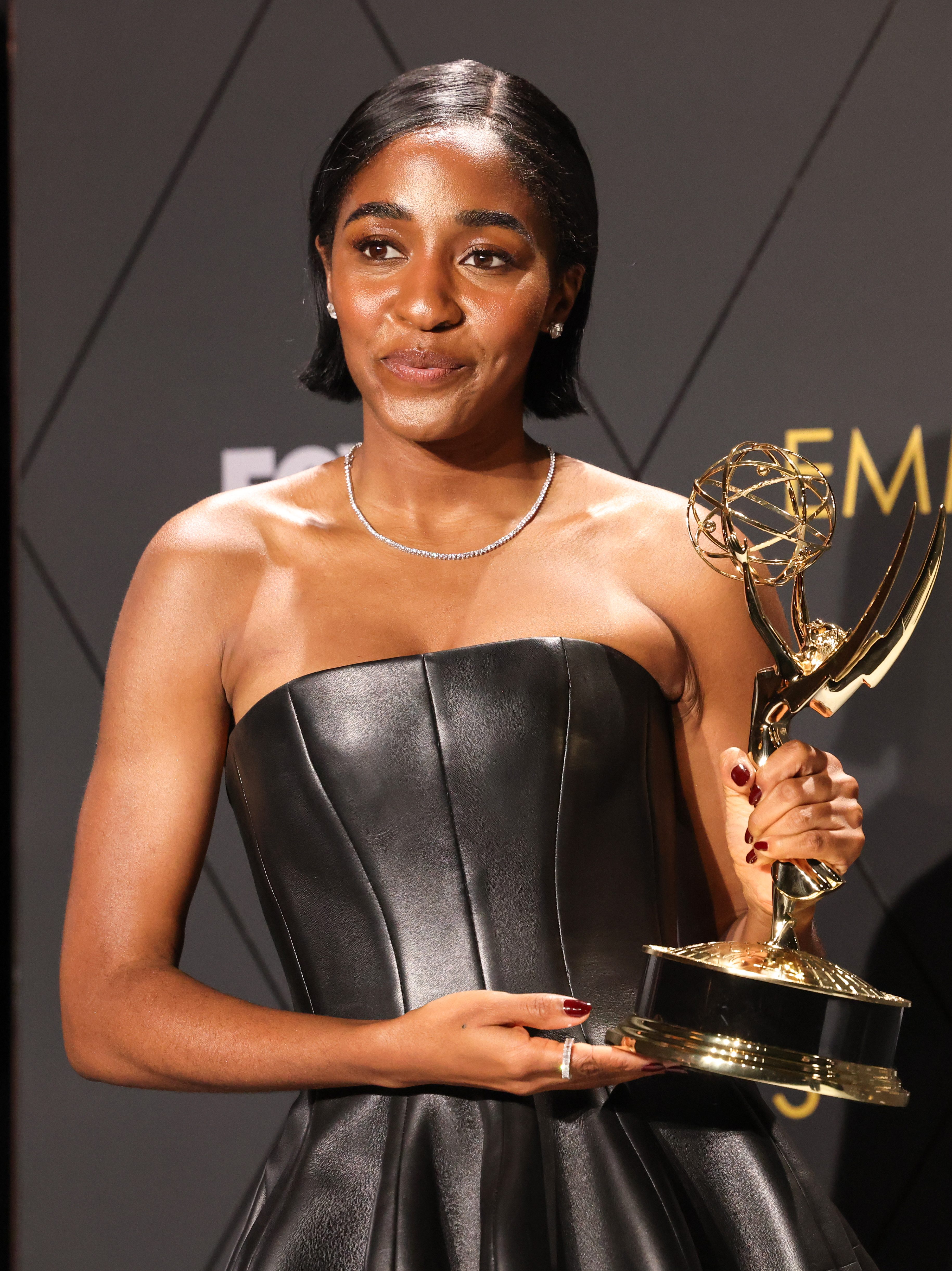 Ayo Edebiri holding up her Emmy Award
