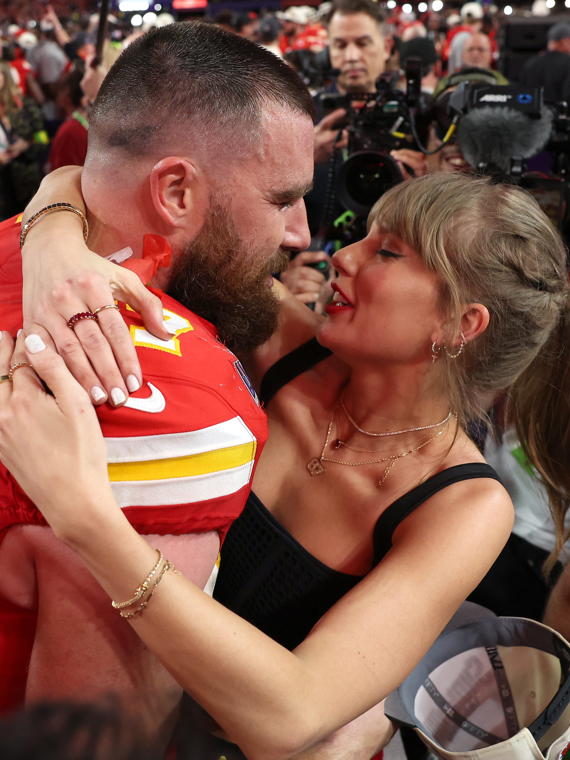 Travis Kelce and Taylor Swift share a kiss at a Chiefs game