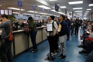 Elias Dubaie ( center l to r) of San Francisco and Kahlai Pratt of San Francisco watch a sign board while they wait in line to apply for the Real ID at the DMV on Fell Street on Friday, January 24, 2020 in San Francisco, Calif. (Photo By Lea Suzuki/The San Francisco Chronicle via Getty Images)