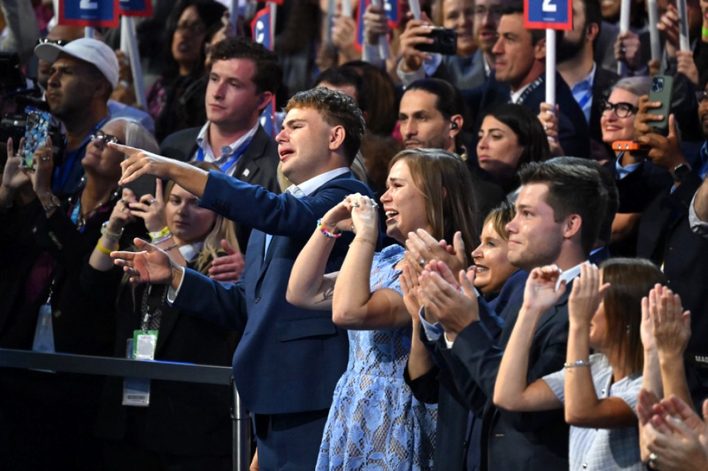 TOPSHOT - Minnesota Governor and 2024 Democratic vice presidential candidate Tim Walz's son Gus (L) and daughter Hope (2nd L) react as he speaks on the third day of the Democratic National Convention (DNC) at the United Center in Chicago, Illinois, on August 21, 2024. Vice President Kamala Harris will formally accept the party's nomination for president at the DNC which runs from August 19-22 in Chicago. (Photo by ANDREW CABALLERO-REYNOLDS / AFP) (Photo by ANDREW CABALLERO-REYNOLDS/AFP via Getty Images)