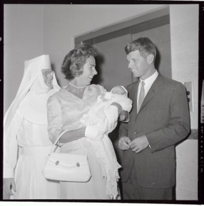 (Original Caption) Mrs. Ethel Kennedy, (L), holds sleeping 8 day old Christopher George, her eighth child, while her husband, Attny. General Robert F. Kennedy looks on, as the couple leave St. Elizabeth's Hospital. they drove to Logan International Airport where they boarded a plane for Hyannis Port.