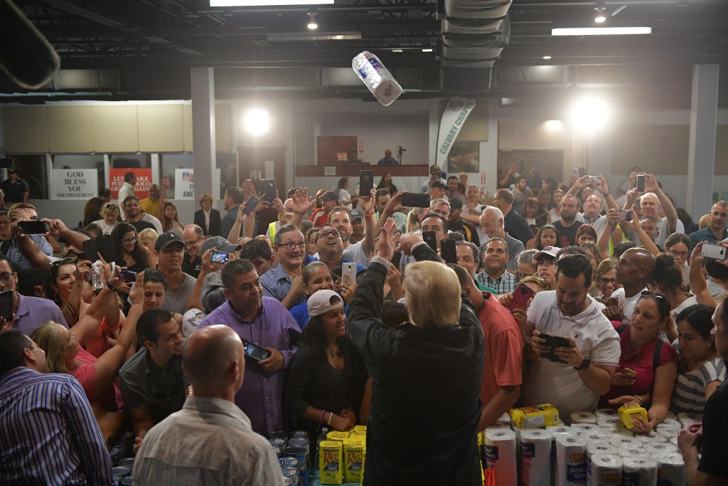 US President Donald Trump takes part in a food and suplly distribution at the Cavalry Chapel in Guaynabo, Puerto Rico on October 3, 2017.Nearly two weeks after Hurricane Maria thrashed through the US territory, much of the islands remains short of food and without access to power or drinking water. / AFP PHOTO / MANDEL NGAN (Photo credit should read MANDEL NGAN/AFP via Getty Images)