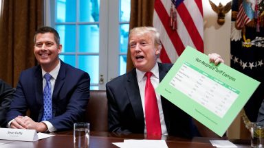 US President Donald Trump, with US Congressman Sean Duffy (L), holds a tariff table as he speaks in the Cabinet Room of the White House on January 24, 2019. - Trump spoke about the unfair trade practices at play in the world. (Photo by MANDEL NGAN / AFP)        (Photo credit should read MANDEL NGAN/AFP via Getty Images)