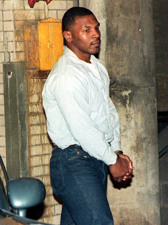 Convicted rapist Mike Tyson walks into the Marion County Courthouse in handcuffs 13 June 1994 before his sentence reduction hearing in Indianapolis, IN. Testimony is being heard on whether the former champion boxer's behavior in prison should warrant an early release. (Photo by EUGENE GARCIA / AFP) (Photo by EUGENE GARCIA/AFP via Getty Images)