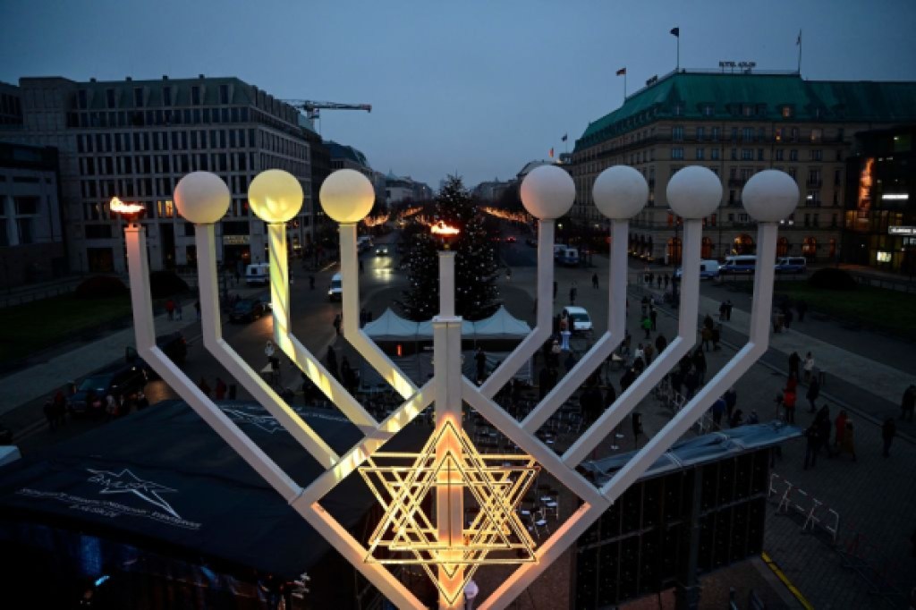 A photo taken on December 18, 2022 from a lifting platform shows a view on a large menorah candelabra after the first flames were lit to celebrate the Chanukka festival, in front of the Brandenburg Gate in Berlin. (Photo by John MACDOUGALL / AFP) (Photo by JOHN MACDOUGALL/AFP via Getty Images)