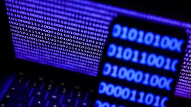 A binardy code displayed on a laptop screen and a binary code displayed on a phone screen are seen in this illustration photo taken in Krakow, Poland on October 30, 2023. (Photo by Jakub Porzycki/NurPhoto via Getty Images)