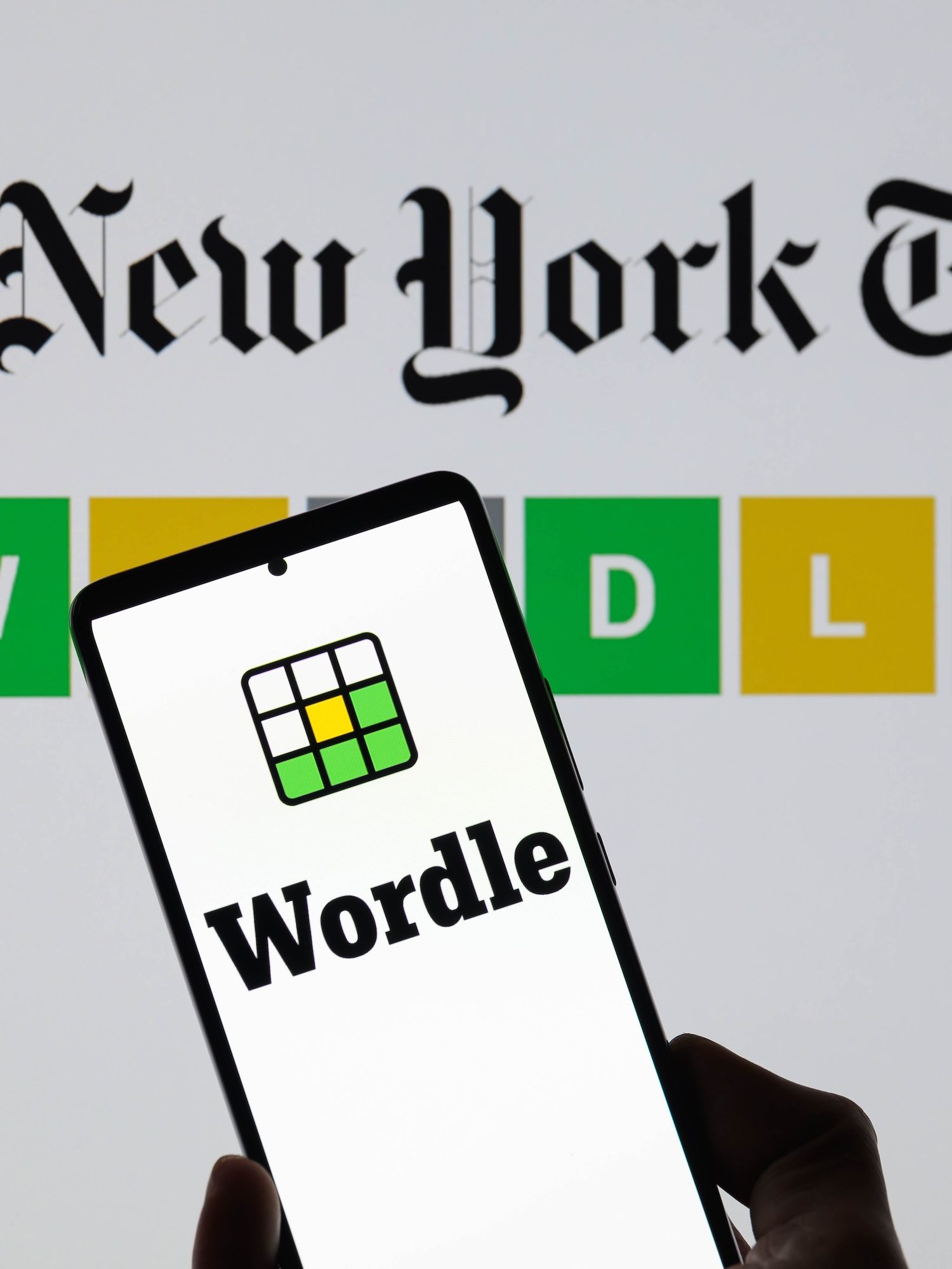 The Wordle logo is being displayed on a smartphone with The New York Times visible in the background in this photo illustration in Brussels, Belgium, on June 1, 2024. (Photo by Jonathan Raa/NurPhoto)