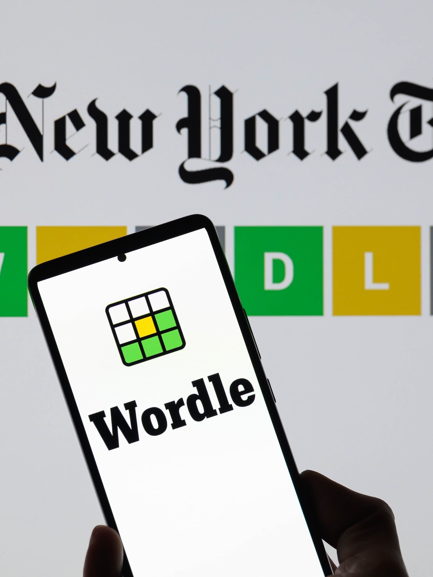 The Wordle logo is being displayed on a smartphone with The New York Times visible in the background in this photo illustration in Brussels, Belgium, on June 1, 2024. (Photo by Jonathan Raa/NurPhoto)