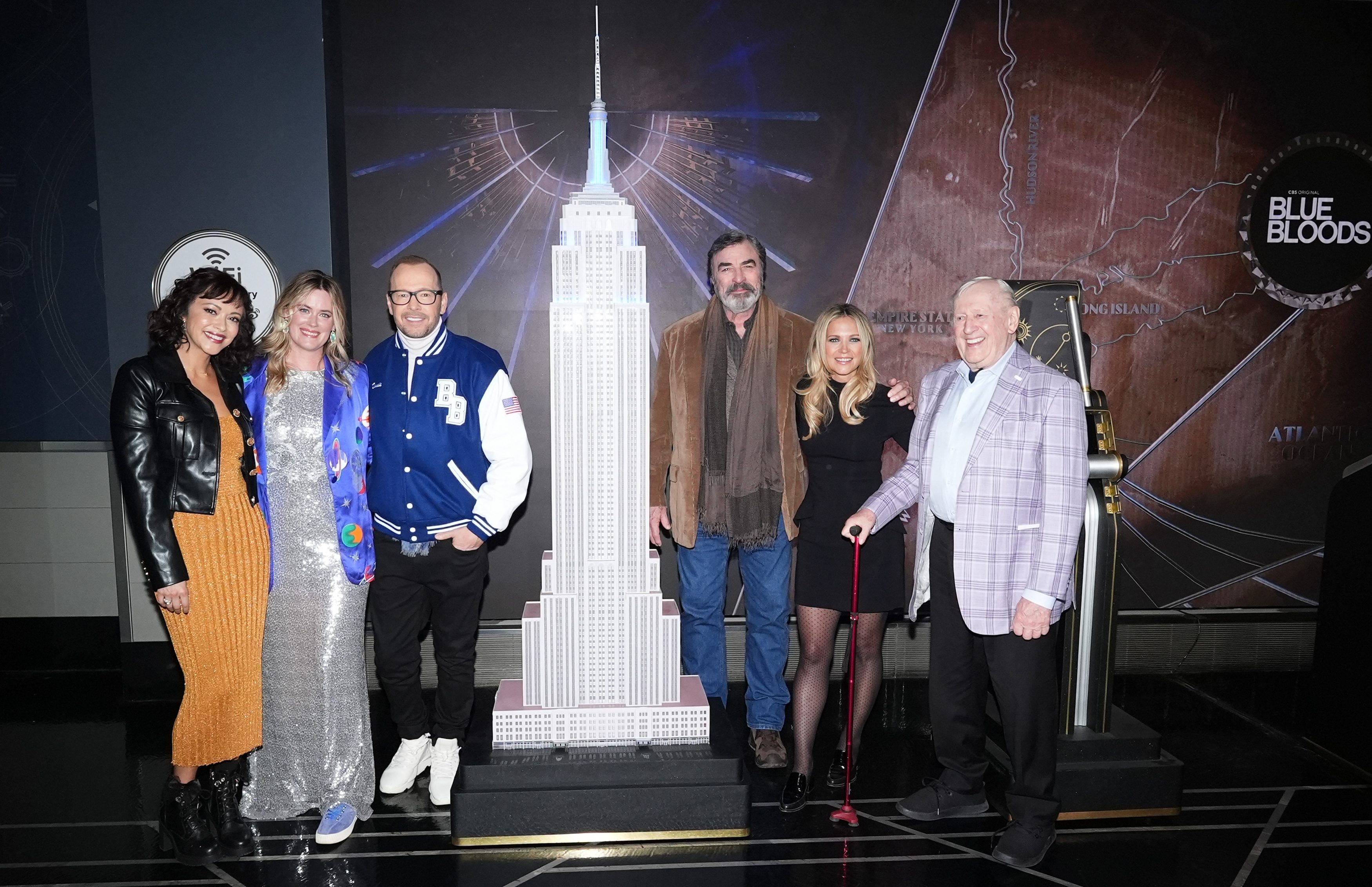 NEW YORK, NEW YORK - OCTOBER 18: (L-R) Marisa Ramirez, Abigail Hawk, Donnie Wahlberg, Tom Selleck, Vanessa Ray and  Len Cariou light the Empire State Building in partnership with CBS and DEA Widows' and Children's Fund in celebration of the final season of "Blue Bloods" at The Empire State Building on October 18, 2024 in New York City. (Photo by John Nacion/Getty Images for Empire State Realty Trust)