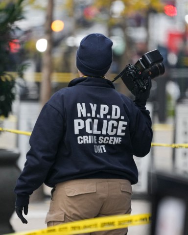 A Crime Scene Unit officer photographs the scene where CEO of UnitedHealthcare Brian Thompson, 50, was shot as he entered the New York Hilton early on December 4, 2024 in New York. Brian Thompson, the chief executive of one of the United States's largest health insurance companies, UnitedHealthcare, was shot and killed outside a New York Hilton hotel in an apparently targeted hit Wednesday, US media reported. (Photo by Bryan R. SMITH / AFP) (Photo by BRYAN R. SMITH/AFP via Getty Images)