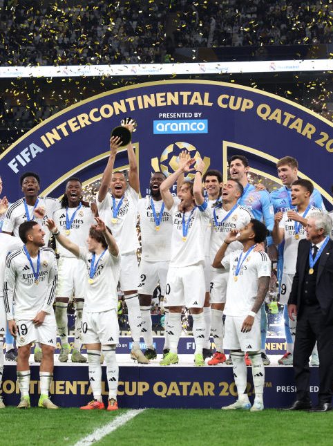 DOHA, QATAR - DECEMBER 18: Kylian Mbappe of Real Madrid lifts the 2024 FIFA Intercontinental Cup trophy as Real Madrid players celebrate their victory at the end of the FIFA Intercontinental Cup between Real Madrid and CF Pachuca at Lusail Stadium on December 18, 2024 in Doha, Qatar.  (Photo by Christopher Pike - FIFA/FIFA via Getty Images)